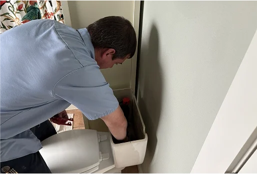 Home 1 A plumber performing work on a toilet in a Texas home.